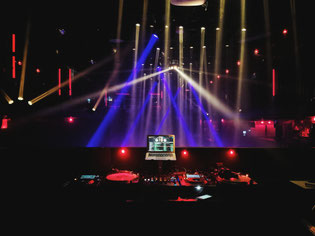 <img src="bilddatei.jpg" alt="DJ Pult und Lichtshow auf einem Event">