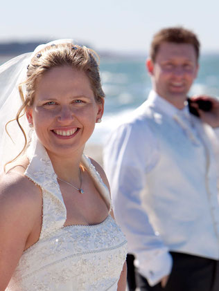 Hochzeit auf Hiddensee, Brautpaar am Ostseestrand,  Braut im Vordergrund, Bräutigam im Hintergrund, halbe Figur