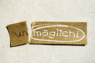 zerrissener Zettel auf dem unmöglich steht