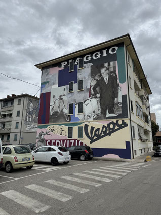 Enrico Piaggio mit seinen Vespas auf einer Häuserwand