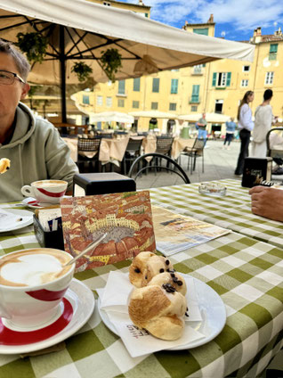Cappuccino und Gebäckzopf auf dem runden Platz in Lucca