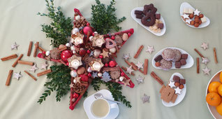Weihnachtliche Tischdeko mit einem Stern, Gewürzen und Gebäck.