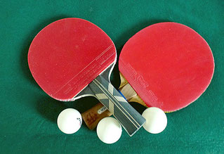 2 gekreutzten Tischtennisschläger mit Bällen