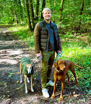 Marlon auf einem Spaziergang im Wald mit seinen Hunden Neo und Belle.