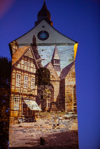 Außenwand einer Kirche, auf die historische Häuser projeziert werden