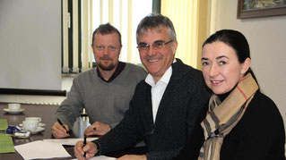 Bianca de Waal-Schneider, Peter Gefeller und Dr. Claus M. Brodersen (von rechts) unterschreiben den Vertrag. (Foto: khn)