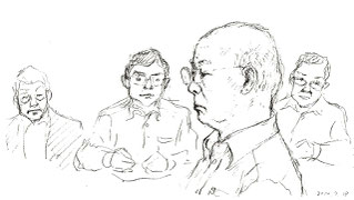 法廷で証言する小山さん。後ろは被告九電の弁護士