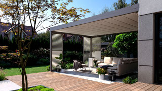 Moderne Pergola mit Faltdach bzw. Planendach auf der Terrasse mit hochwertigen Möbeln..