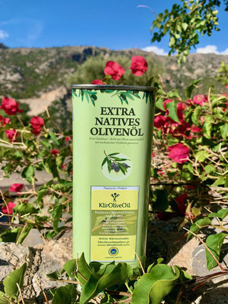 KlirOliveOil Olivenöl im grünen Kanister mit roten Blumen und blauem Himmel