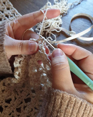 Cette photo représente un groupe de personnes en train de crocheter autour d'un goûter