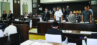 ヘリパッド反対派を批判する意見書に起立して賛成する与党(右側)=24日午前、議場