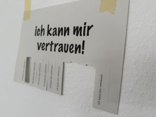 Zettel mit dem Schriftzug: "ich kann mir vertrauen" und unten sind Abschnitte zum Abreißen zu sehen