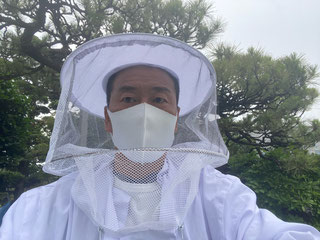 白い蜂の防護服を着た駆除職人