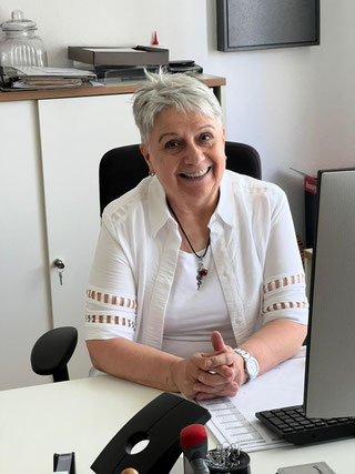 Hier sitzt Jolanta Nüllig als kommissarische Pfarr- und Gemeindesekretärin am Schreibtisch und blickt in die Kamera