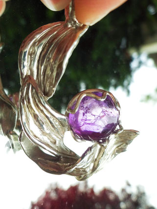 Un pendentif avec des feuilles sculptées en argent a en son centre une très belle améthyste violette.