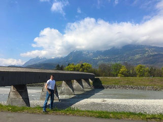 Auf der alten Rheinbrücke in Vaduz. Noch befinde ich mich auf liechtensteinischem Boden. Nach passieren der Holzbohlen, unter denen recht lautstark der schmale Rhein dahinfließt, stehe ich auf schweizerischem Territoriom.