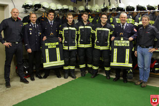 Vertreter der Lieferfirma (jeweils außen) mit den Führungskräften der Freiwilligen Feuerwehren aus Ascha und Falkenfels bei der Übergabe der neuen Schutzkleidung im Gerätehaus der Feuerwehr Falkenfels