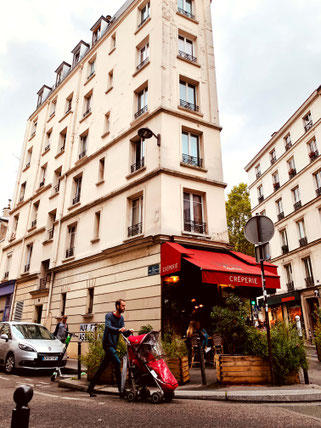 man with stroller in front of Crêperie