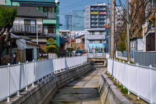 水のない時期の中井筋。後方にJRゲートタワーなどが見える