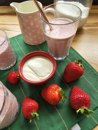 Erdbeermilkshake gekühlt im Glas mit Erdbeeren und Joghurt dekoriert