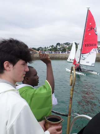 Le père Simon bénit les bateaux un à un, plus d'une vingtaine cette année