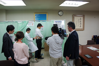 専用の機器を用いて職場で内臓脂肪を測定 ※カメラはテレビ局の取材