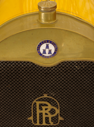 Calandre d'une Rolland-Pilain de 1908 avec emblème de marque / 4 voitures engagées.