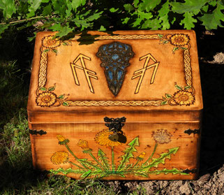 Handgefertigte Samenkiste aus Kiefernholz Eine individuell gefertigte Samenkiste mit eingebrannten und kolorierten Pflanzenmotiven aus Sonnenblume, Löwenzahn, Königskerze und Ringelblume. Antikbeschläge und ein Segensspruch im Deckel machen sie zu einem b