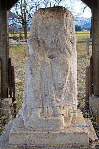 weibliche Steinfigur, sitzend mit in Falten gelegten Kleidern, ohne Kopf