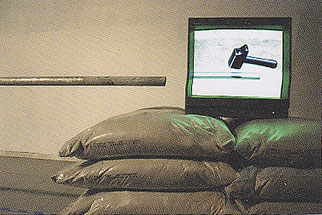 ‘Power plays’: Tentoonstellingszicht met gestapelde zandzakken in de ruimte; bovenop staat een monitor waarop een hamer wordt getoond, Z33, Hasselt, 2006.