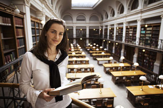 mädchen mit buch in bibliothek 