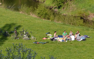 Radfahrer:innen bei einem Picknick im Park an der Ilm