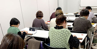 中高年の女性が集まるそろばん式脳トレーニングの受講中の教室