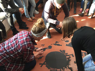 Schüler erstellen Collage mit Schere und schwarzem Tonpapier