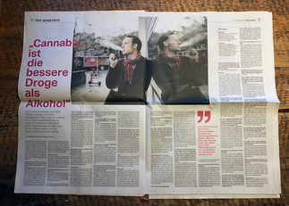 Aufgeschlage Tageszeitung in der ein Doppelseitiger Artikel zu sehen ist. 