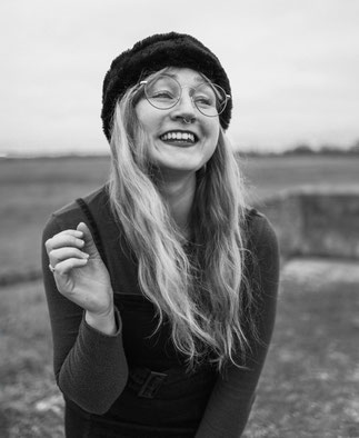 Schwarz weiß Portrait von Fotografin Malina Bura auf einem Deich in der Altmark