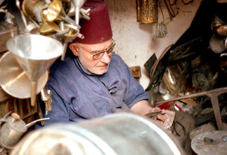 ein Metall-Handwerker der noch einen Fes aus roten Filz trug