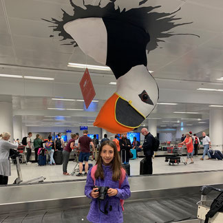 Margherita al nastro bagagli sotto un puffin gigante