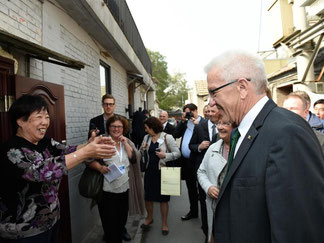Ministerpräsident Winfried Kretschmann (r, Grüne) spricht mit einer Chinesin. Foto: Reiner Pfisterer
