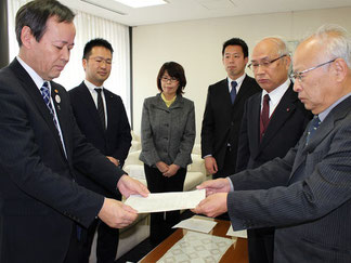 申し入れ書を手渡す小村吉一党市委員長(右)