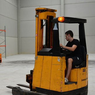 homme sur transpalette jaune dans hangar