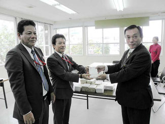 年賀はがきを託す、仲島局長(中)=市教育委員会