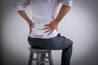 腰痛で腰を抑える男性