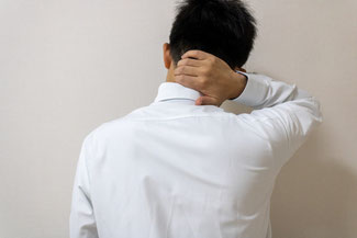 ムチウチで首を抑える男性