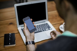 Mensch mit Labtop und Handy