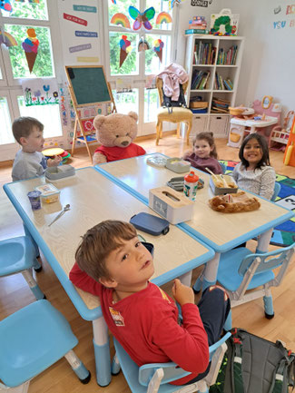 Children enjoying lunchtime together in a friendly English-speaking environment at Custom Kids.