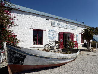 Bild: Alts Fischerboot vor einem Wohnhaus in Paternoster