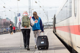 Fotograf und Fotojournalist München. Beispiel Reportagefotografie und Pressefotos: Mitarbeiterin der Bahnhofsmission begleitet einen sehbehinderten Mann.
