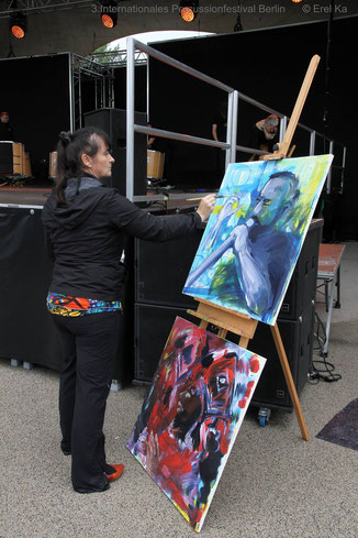 Antje Püpke malt live vor der Bühne des Percussionfestival an ihren Bildern. 