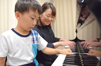 ピアノ講師とリズム遊びをする未就学児